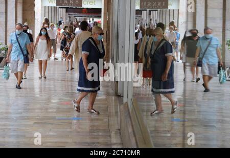 Palma, Spagna. 13 luglio 2020. Una donna che indossa un boccaglio entra in un negozio nel centro di Palma. A Maiorca e nelle altre isole Baleari, un ampio obbligo di mascheramento è di entrare in vigore lunedì a causa della pandemia di Corona. Credit: Clara Margais/dpa/Alamy Live News Foto Stock