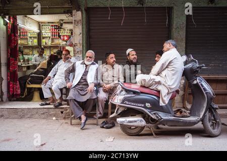 New Delhi / India - 18 febbraio 2020: Gruppo di uomini di Musim seduti fuori del negozio di tè in via di Old Delhi Foto Stock
