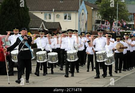 I membri della Shankill Road Defenders flute band marciano attraverso la tenuta di Lower Shankill, Belfast, per le celebrazioni del dodicesimo luglio con le distanze sociali, nonostante il consiglio di rimanere a casa a causa dell'epidemia di coronavirus. Il dodicesimo è celebrato il 13 luglio, mentre il 12 luglio di quest'anno cade di domenica. Foto Stock