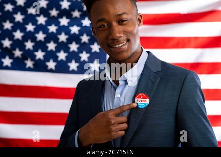 Badge elezioni USA 2020 su vestito di uomo d'affari afro-americano Foto Stock