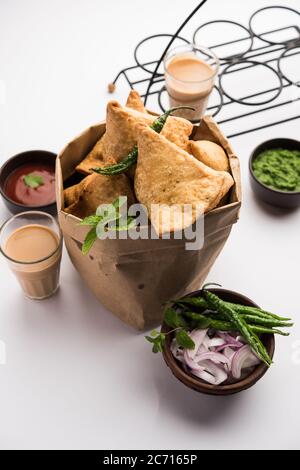 Samosa - pasticceria fritta/cotta a forma triangolare con ripieno di salato, popolari spuntini Indian Tea Time, serviti con chutney verde, ketchup di pomodoro Foto Stock