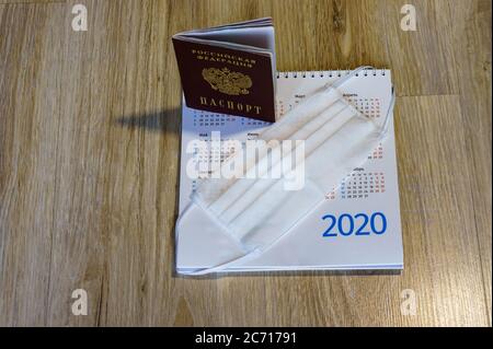 Documento e maschera sanitaria del cittadino russo, maschera medica sul calendario e passaporto Foto Stock