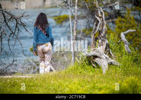 Vista posteriore di donna che cammina lungo un bellissimo sentiero. Foto Stock