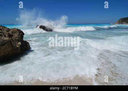 Grandi onde in acque poco profonde, cielo azzurro chiaro dopo la tempesta, bellezza e pericolo di Kathisma spiaggia, Lefkada isola, Grecia Foto Stock