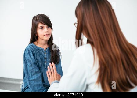 Medico psicoterapeuta, terapeuta o pediatra in camice bianco ascolta la ragazza teen durante la ricezione in clinica. Teen problemi, sessione di terapia. Foto Stock