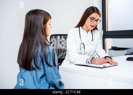 Medico psicoterapeuta, terapeuta o pediatra in camice bianco ascolta la ragazza teen durante la ricezione in clinica. Teen problemi, sessione di terapia. Foto Stock