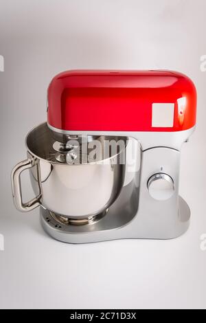 Primo piano di un supporto rosso e argento o di un mixer elettrico da cucina isolato su sfondo bianco con spazio per la copia Foto Stock