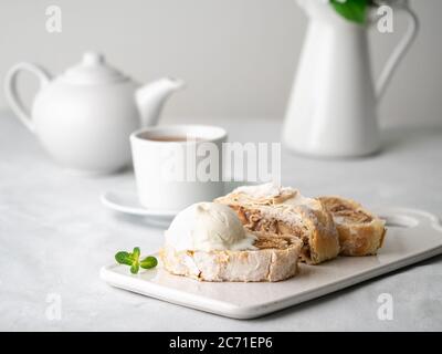 Strudel di mele con gelato e cannella. Torta al forno e tè, delizioso dessert Foto Stock