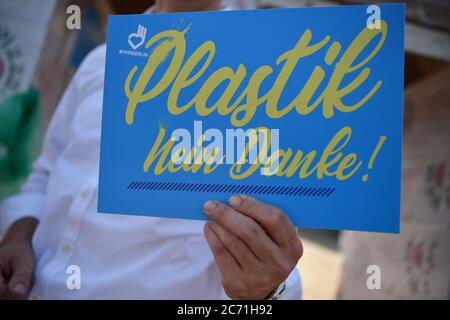 Berlino, Germania. 02 luglio 2020. Durante l'inaugurazione del 'üllburger Tor' al lido di Plötzensee, un uomo tiene in mano un segno che recita 'No grazie plastica. L'installazione di 5 metri di larghezza e 2 metri di altezza, a forma di porta di Brandeburgo, composta da scatole per pizza, tazze da asporto, bottiglie di plastica e altri rifiuti di imballaggio, è destinata a incoraggiare le persone a evitare i rifiuti. Credit: Sven Braun/dpa/Alamy Live News Foto Stock