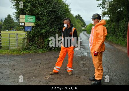 Appaltatori in PPE, in attesa di andare in loco, fuori Rook Row Farm a Mathon, vicino a Malvern, Herefordshire, dove ci sono stati 73 casi positivi di coronavirus confermato. Foto Stock