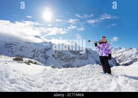 Ritratto sulla cima della montagna di ragazza sciatore sportivo stand e tenere lo sci sulla spalla in piena giornata invernale Foto Stock