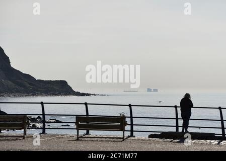 La centrale nucleare di Dungeness si è vista in lontananza attraverso la nebbia marina da Hastings, Inghilterra, Regno Unito Foto Stock