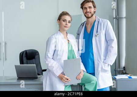Team medico che discute delle opzioni di trattamento con i pazienti. Gruppo di medici che si riunita nella sala riunioni Foto Stock