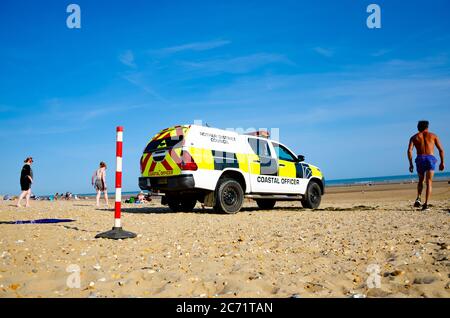 Coastal Officer, pick-up in 4x4 sul lungomare con persone sullo sfondo, Rother District, Camber Beach Sands in Inghilterra. Foto Stock