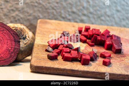 Barbabietola (Beta vulgaris L.) tagliata su una tavola di legno accanto a tuberi rotti. Verdure per insalate. Verdure usate nella cucina brasiliana. Fonte di zucchero pr Foto Stock