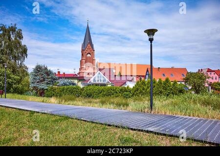Passeggiata a Nowe Warpno con la torre della chiesa sullo sfondo, Polonia. Foto Stock