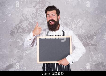 cuoco la tavola vuota. pollice su per successo. miglior menu chef. lavagna con spazio per la copia del testo. panettiere professionale in grembiule. barista felice con barba. pubblicità e cibo. Foto Stock