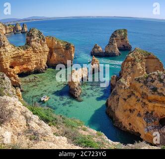 Lagos, Portogallo - Aprile 2018: Barche da pesca su acque turchesi di Ponta da Piedade, regione dell'Algarve, Portogallo Foto Stock