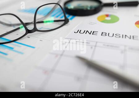 Calendario cartaceo di giugno sul posto di lavoro tra le carte Foto Stock