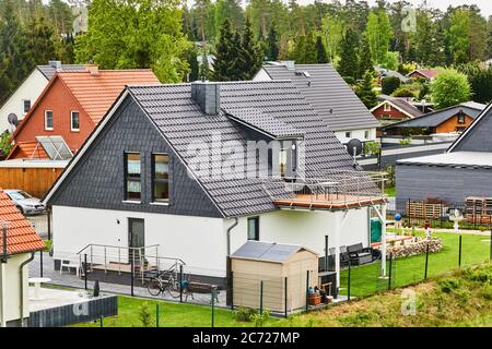 Gifhorn, Germania, 15 maggio 2020: Nuova casa indipendente con vernice bianca e tetto scuro con piccolo giardino con prato in una tenuta di nuovo e stretto alloggio Foto Stock