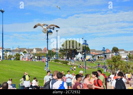 Barry Island, vale of Glam. / Galles - Giugno 24 2020: COVID-19 Social distanzing sulla spiaggia. Il sole è caldo e gli amici e le famiglie si siedono in gruppi 2 Foto Stock