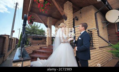 Lo sposo incontra la sposa e le dà un bouquet. Foto Stock