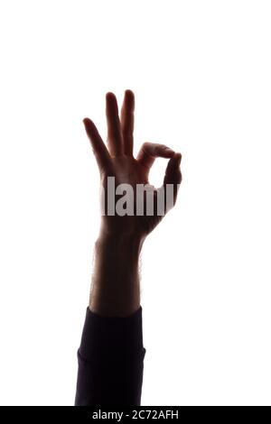 Mano di un giovane uomo mostra il simbolo ok, come e approvazione - silhouette concetto astrazione Foto Stock