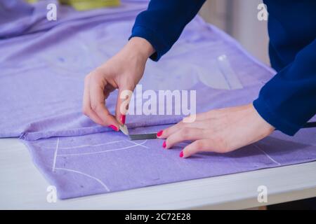 Dressaker professionale, gesso di tenuta e panno di misurazione per cucire presso atelier. Concetto di moda e sartoria Foto Stock