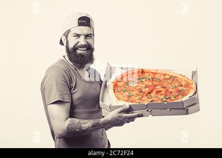 Sorridente giovane addetto alla consegna che tiene la scatola della pizza. Foto Stock