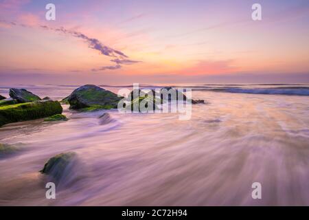Sognare l'alba pacifica su Jersey Shore dopo che ha tempesta caratterizzato le onde belle in primo piano Foto Stock