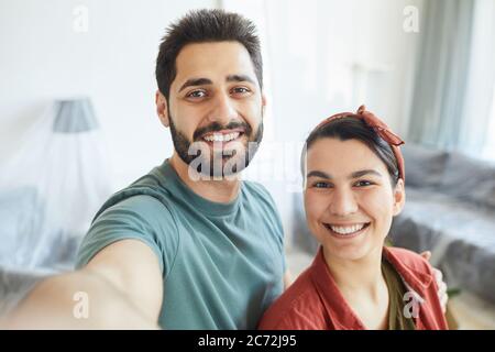 Ritratto di giovane coppia felice sorridente alla fotocamera che fanno selfie ritratto a casa Foto Stock