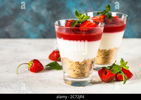 Cheesecake nei bicchieri con fragola fresca. Foto Stock