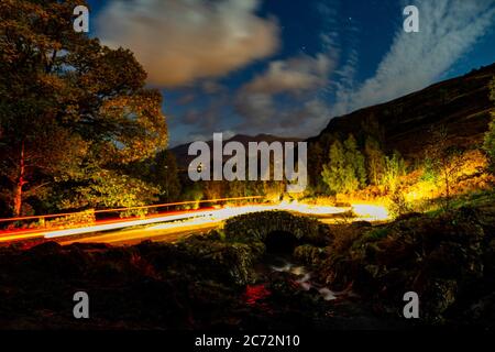 Percorsi in auto sul ponte Ashness in una notte nuvolosa Foto Stock