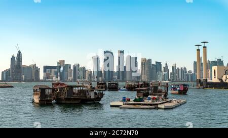 Doha, Qatar - Febbraio 2019: Skyline del Qatar di Doha con le tradizionali barche in samche Qatar nel porto Foto Stock