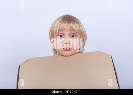 Sorpreso sconvolto ragazzo dai capelli giusti con scatola in mano su sfondo bianco. Consegna pizza. Foto Stock