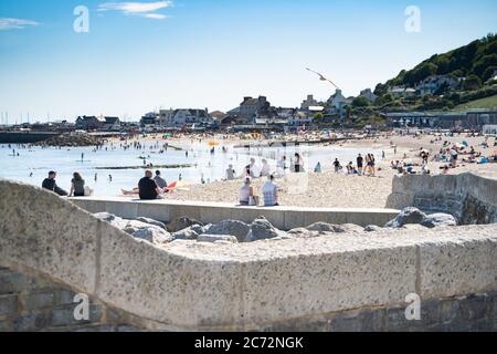 Una spiaggia trafficata in estate, Lyme Regis, Dorset, Regno Unito Foto Stock