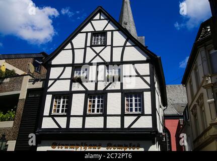 Kempen, Germania - 9 luglio. 2020: Vista sulla facciata bianca medievale in legno casa con chiesa cattolica torre dell'orologio in estate con cielo blu Foto Stock