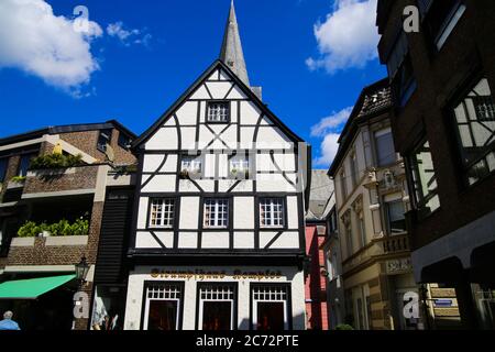 Kempen, Germania - 9 luglio. 2020: Vista sulla facciata bianca medievale in legno casa con chiesa cattolica torre dell'orologio in estate con cielo blu Foto Stock