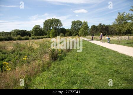 Famiglia in bicicletta su nuove piste ciclabili a Long Marston Garden Village, proposto lo sviluppo di comunità di 4000 attraente ben progettato casa di alta qualità Foto Stock