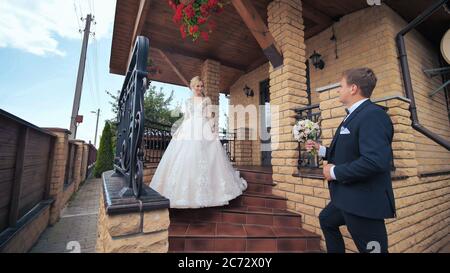 Lo sposo incontra la sposa e le dà un bouquet. Foto Stock