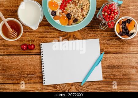 Bianco bianco di diario alimentare, sana colazione di granola con frutta, latte e miele su tavola di legno. Vista dall'alto Foto Stock