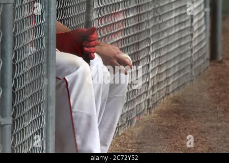 Due giocatori di baseball si siedono sulla panchina in attesa della partita. Foto Stock