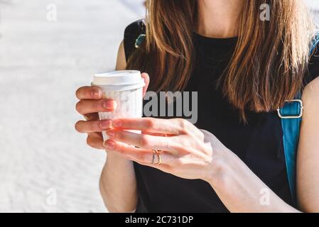 mani di donna caucasica che tengono una tazza di carta di caffè da asporto Foto Stock