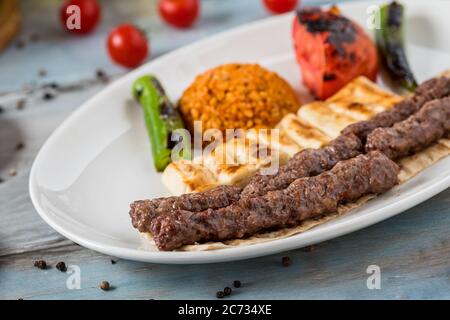 shish meatball kebab di cucina turca, servito con piatto bianco su tavolo di legno. Foto Stock