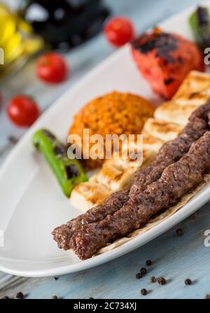 shish meatball kebab di cucina turca, servito con piatto bianco su tavolo di legno. Foto Stock