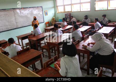 Studenti che indossano la maschera facciale, studiano durante una sessione di classe alla Jetis 3 Vocational High School Yogyakarta, Indonesia. 13 luglio 2020. Il governo indonesiano ha iniziato a riaprire le scuole attuando processi di apprendimento faccia a faccia in mezzo alla pandemia del coronavirus, specialmente nelle zone verdi in diverse regioni. Il governo ha iniziato ad allentare la COVID-19, una parziale restrizione di blocco nel tentativo di riavviare l'economia dopo più di tre mesi di sconvolgimento causato dalla pandemia in corso. (Foto di Devi Rahman/INA Photo Agency/Sipa USA) Credit: Sipa USA/Alamy Live News Foto Stock