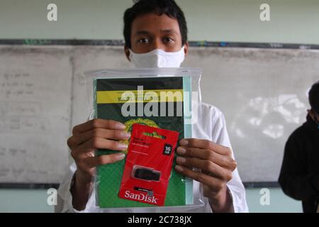 Studenti che indossano la maschera facciale, studiano durante una sessione di classe alla Jetis 3 Vocational High School Yogyakarta, Indonesia. 13 luglio 2020. Il governo indonesiano ha iniziato a riaprire le scuole attuando processi di apprendimento faccia a faccia in mezzo alla pandemia del coronavirus, specialmente nelle zone verdi in diverse regioni. Il governo ha iniziato ad allentare la COVID-19, una parziale restrizione di blocco nel tentativo di riavviare l'economia dopo più di tre mesi di sconvolgimento causato dalla pandemia in corso. (Foto di Devi Rahman/INA Photo Agency/Sipa USA) Credit: Sipa USA/Alamy Live News Foto Stock