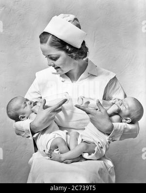 1930 SORRIDENTE INFERMIERE SEDUTA TENENDO GIOCOLERIA DUE NEONATI TWIN BABY GIRL SUORE NELLE BRACCIA CHE LI NUTRONO CON BIBERON - N1762 HAR001 HARS NEONATO IL SUO VECCHIO TEMPO OCCUPATO FUTURO NOSTALGIA INFERMIERI VECCHIA SORELLA DI MODA 1 ALIMENTAZIONE GIOVANI CARRIERA BIBERON GIOVANE ADULTO EQUILIBRIO INFERMIERISTICO LAVORO DI SQUADRA NEONATO TWIN GIOIA STILE DI VITA FEMMINE LAVORI SALUTE COPIARE SPAZIO FULL-LENGTH MEZZA LUNGHEZZA SIGNORE FISICA FITNESS PERSONE ISPIRAZIONE PROFESSIONE CURA SERENITÀ FRATELLI SPIRITUALITÀ FIDUCIA SORELLE B&W SANITÀ ABILITÀ AFFAMATA OCCUPAZIONE FELICITÀ COMPETENZE BENESSERE PROVIDER PROFESSIONISTI PROTEZIONE FORZA Foto Stock