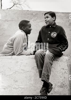 ANNI '60 DUE SPENSIERATI IMPEGNATI TEENAGE AFROAMERICANI RAGAZZI INDOSSARE GIACCHE SEDUTI SU MURO URBANO DI CEMENTO SORRIDENTE PARLARE INSIEME - N1954 HAR001 HARS GIOVANILE PAURA COMUNICAZIONE SICUREZZA LAVORO DI SQUADRA STILE DI VITA FRATELLI CASA VITA AMICIZIA PERSONE ISPIRAZIONE MASCHI RISCHIO ADOLESCENTE RAGAZZO FRATELLI FRATELLI CONFIDENZA ESPRESSIONI B&W TRISTEZZA OBIETTIVI VISIONE TENTAZIONE FELICITÀ FORZA AFROAMERICANI CORAGGIO AFROAMERICANO SCELTA CONOSCENZA LEADERSHIP PROGRESSO NERO ETNIA DIREZIONE ORGOGLIO SU FIDANZATO SENTIMENTO DI CONNESSIONE IMMAGINARIO CONCETTUALE TEENAGED SPENSIERATO COOPERAZIONE EMOZIONE EMOTIVA Foto Stock