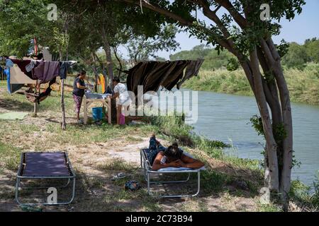 Matamoros, Messico. 13 luglio 2020. Si vedono persone in attesa in isolamento in una zona recintata off sulle rive del Rio Grande. Attualmente ci sono 23 persone che aspettano in isolamento per essere testate o per i risultati dei loro test del coronavirus. 3 dei residenti del campo hanno provato positivi per il virus. Ci sono circa 1,500 persone che vivono in tende all'interno di una zona recintata fuori del parco mentre attendono le loro audizioni di asilo negli Stati Uniti d'America. Credit: Cripps/Alamy Live News Foto Stock